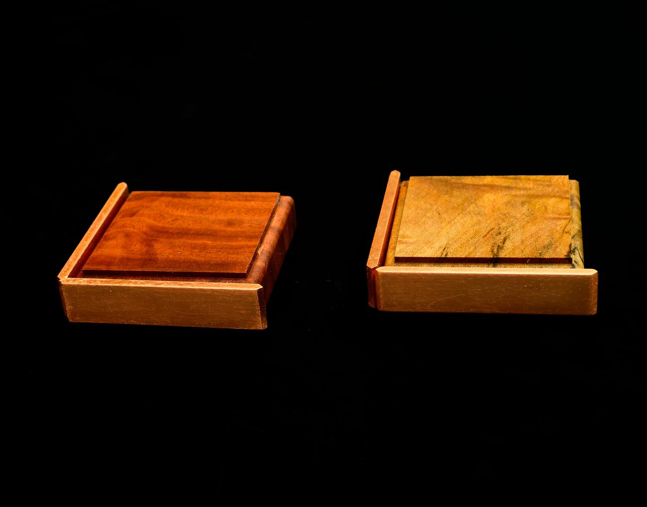 Two tiles set edge to edge with copper fitted along their front and side faces